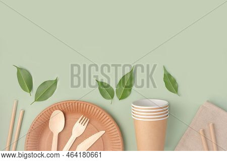 Eco - Friendly Tableware On Green Background. Top View. Plastic Free Set Of Brown Paper Utensil. Str