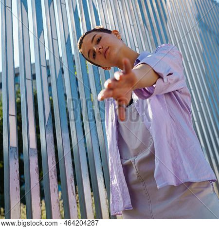Portrait Beautiful Teenage Girl Short Hair, In Unisex Clothes, Holding Out Hand To An Imaginary Pers