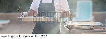 Close-up Of Chef Carry Cooked Meal, Metal Construction For Frying Food, Do Grill, Picnic Outdoors, F