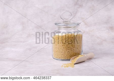 Traditional Dry Pearl Couscous In A Glass Jar On A Light Background. Selective Focus.