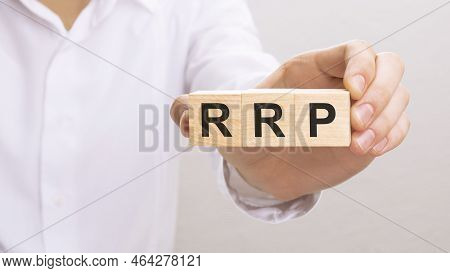 Hand Holding Wood Cubes With Rrp Text. Financial, Management, Economic, Business Concept.