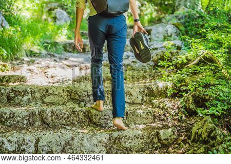 Man Tourist Climb Barefoot The Mountain To The Ostrog. It Is A Tradition To Climb Barefoot. Monaster