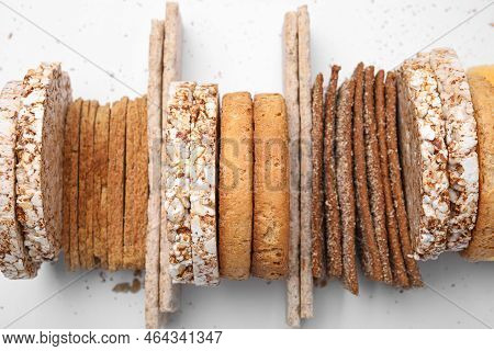 Many Fresh Rye Crispbreads, Crunchy Rice Cakes And Rusks On White Background, Top View