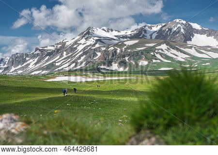 Climbers With Hiking Backpacks Go To The Mountain. Hikers In Mountains. Tourists Hike On Rocky Mount