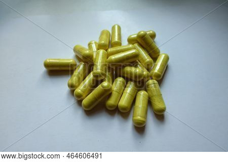 Handful Of Greenish Yellow Capsules Of Quercetin Dietary Supplement