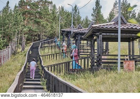 Ulan-ude, Russia - August 17, 2022: Woman Going Wooden Footpath For Ritual Detour Around Datsan. Arb