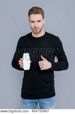 Thumb Up. Unbranded Cosmetic For Man. Handsome Man Hold Bottle Of Unbranded Cosmetic