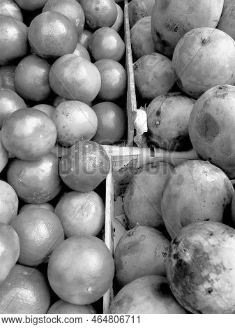 Black And White Oranges And Mangoes On Sale In A Fruit Market Stall