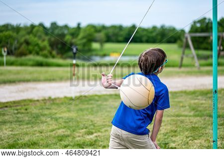 Tetherball Being Hit And Roped In A Game With A Young Boy.