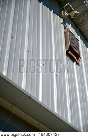 Wooden Bat House On White Corrugated Tin Barn
