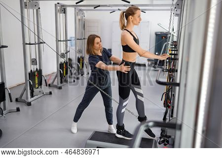Woman Doing Exercise On Decompression Simulators With Trainer Rehabilitation. Sports Physiotherapist