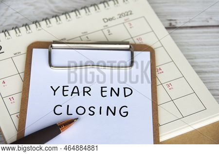 Year End Closing Text On White Notepad With December Calendar Background. Year End Closing Concept.