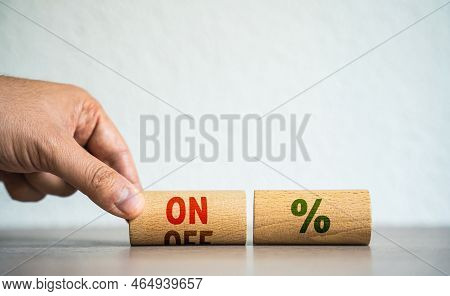 A Man Holds Wooden Blocks With The Word On And Off Percentage. Payment Or Non-payment Of Interest On