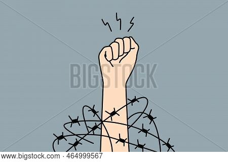 Close-up Of Hand In Fist In Wires Thrive For Independence And Freedom. Raised Hand With Clenched Fis