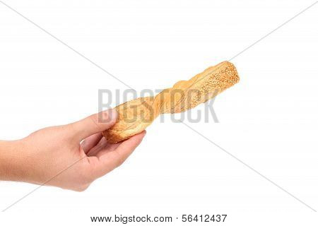 Hand holds crunchy puff pastry with sesame.