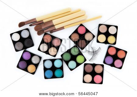 Various eyeshadow palettes, fake eyelashes and cosmetic brushes, isolated on white