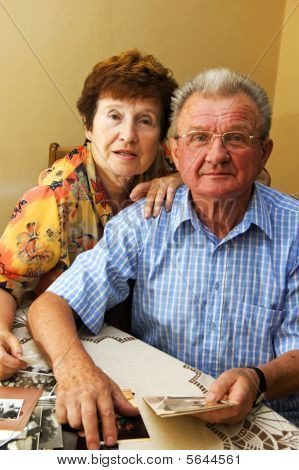 Senior paar kijken naar oude foto's.