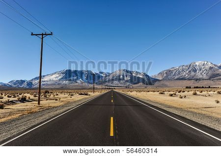 Road To Mountains With Telephone Poles On Side