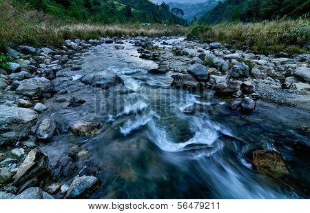 River Water Flowing Through Rocks At Dawn