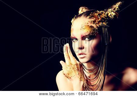Art project: beautiful woman with golden make-up. Jewelry, make-up. Fashion. Over black background.