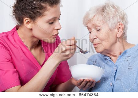 Nurse Feeding An Older Lady