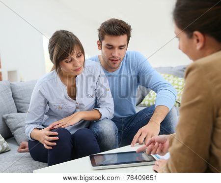 Young couple signing financial contrat on digital tablet
