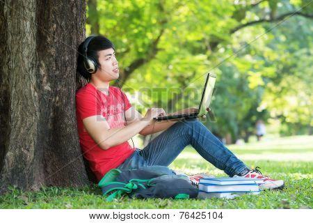 Portrait Of Student Relaxing In The Park.