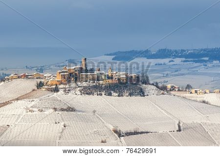 Small town of Castiglione Falletto on hill covered with snow in Piedmont, Northern Italy.