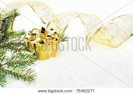 Gold Christmas Gifts With Gold Ribbon And Needles Fir On Snow