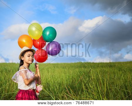 Young Asia Girl Holds Tightly To A Large Bunch Of Helium Filled Balloons