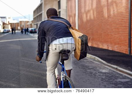 Black african mad riding bicycle in urban city commuting with speed and hipster trendy transportation