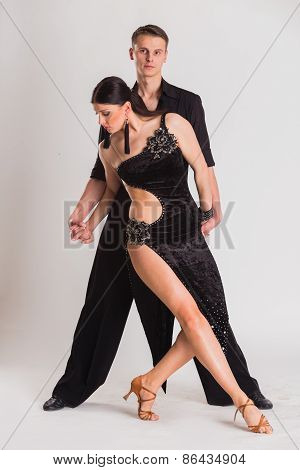 Man and woman posing in dance pose on white