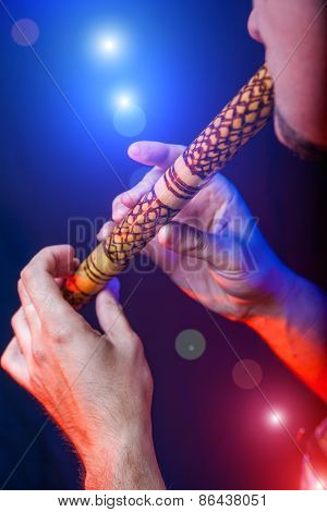 Folk musician in concert plays the melody on the Ethnic Flute