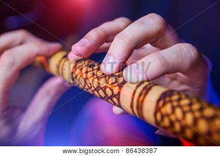 Folk musician in concert plays the melody on the Ethnic Flute