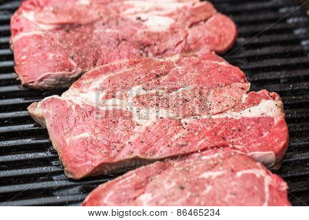Fresh beef steaks on grill