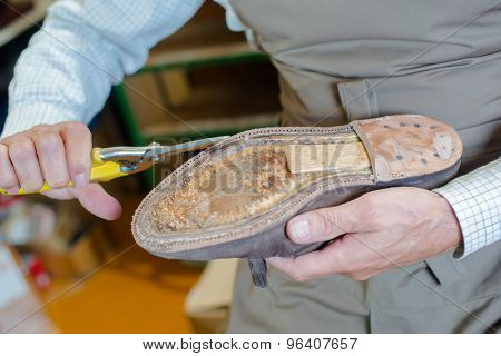Shoe maker preparing a shoe