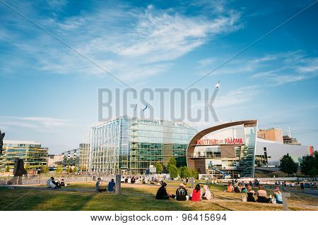 People are relaxing in front of the Kiasma museum and Sanoma bui