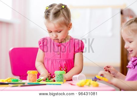 Children mould from clay in play room. Preschool.