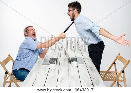 Business conflict. The two men expressing negativity while one man grabbing the necktie of her oppon