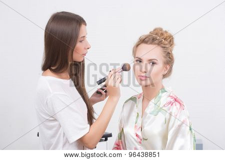 Makeup artist on applying blush on cheeks with blush brush