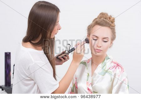Makeup artist on applying blush on cheeks with blush brush