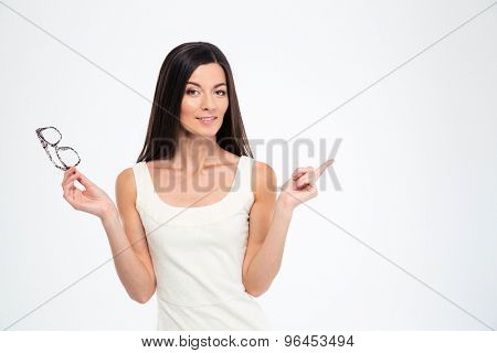 Hapyp woman holding glasses and pointing finger away isolated on a white background