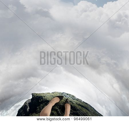 Close up of woman legs standing on the edge of rock