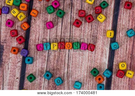 aproval - word created with colored wooden cubes on desk.