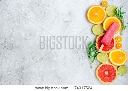 homemade citrus popsicles with fresh fruit slices on stone table background top view mockup