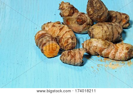 Fresh Turmeric or Curcuma root on blue wooden background with copy space