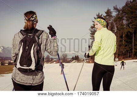 Pair of skiiers taking a break and talking. Cross country skiing.