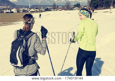 Pair of skiiers taking a break and talking. Cross country skiing.