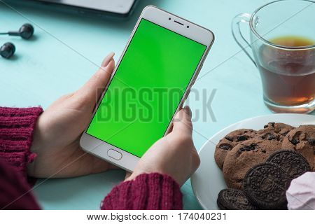Beautiful girl holding a smartphone in the hands of a green screen green screen, hand of man holding mobile smart phone with chroma key green screen on white background, new technology concept