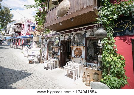 KALKAN, TURKEY - MAY 22 Storefront of antique shop decorated with shelves with antique metal trays jugs lanterns and other souvenires on cobblestone paved narrow streets of Kalkan 216